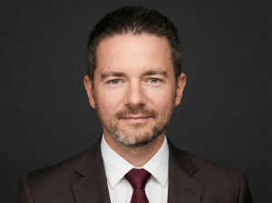 Владислав Наганов, официальный деловой портрет в темном костюме на нейтральном фоне