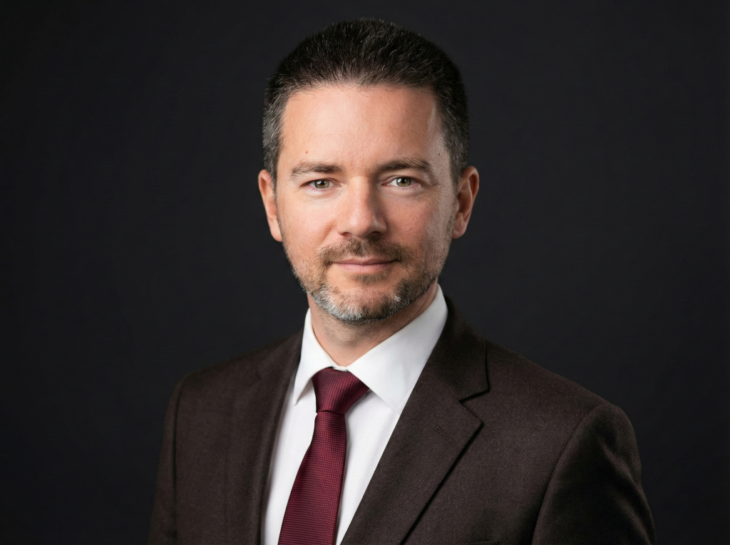 Владислав Наганов, деловой портрет с прямым взглядом на черном фоне